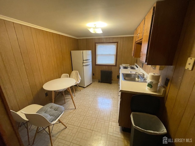 309 S 2nd Ave S, Highland Park, NJ 08904 - kitchen featuring freestanding refrigerator, radiator heating unit, wood walls, light countertops, and a sink