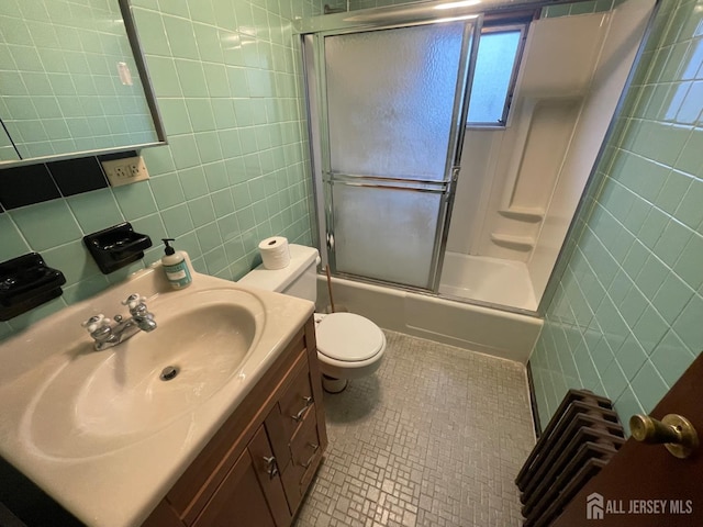 309 S 2nd Ave S, Highland Park, NJ 08904 - bathroom featuring tile walls, tile patterned floors, toilet, vanity, and shower / bath combination with glass door