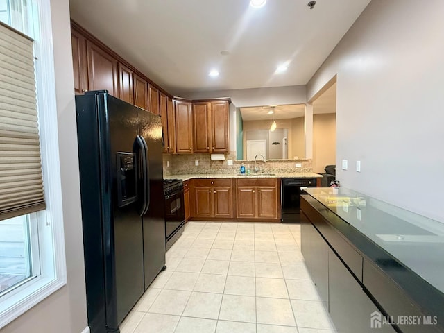 2116 Edward Stec Blvd, Edison, NJ 08837 - kitchen featuring light tile patterned flooring, brown cabinets, tasteful backsplash, a sink, and black appliances