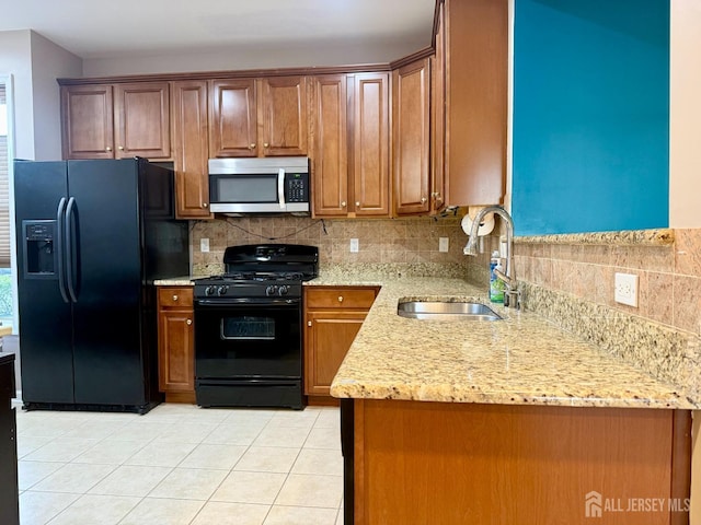 2116 Edward Stec Blvd, Edison, NJ 08837 - kitchen with light stone counters, a sink, backsplash, light tile patterned floors, and black appliances