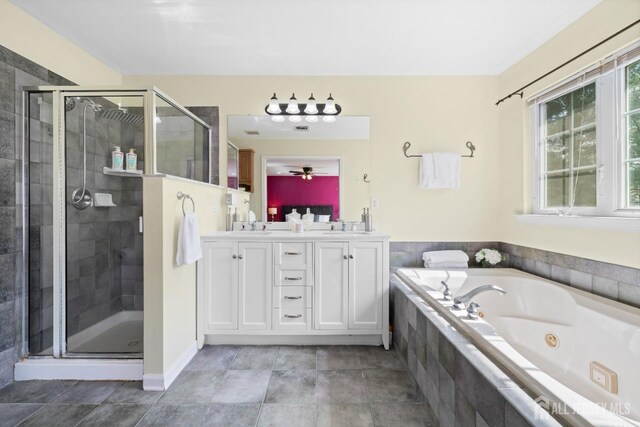 bathroom featuring double vanity, a sink, a tub with jets, and a shower stall