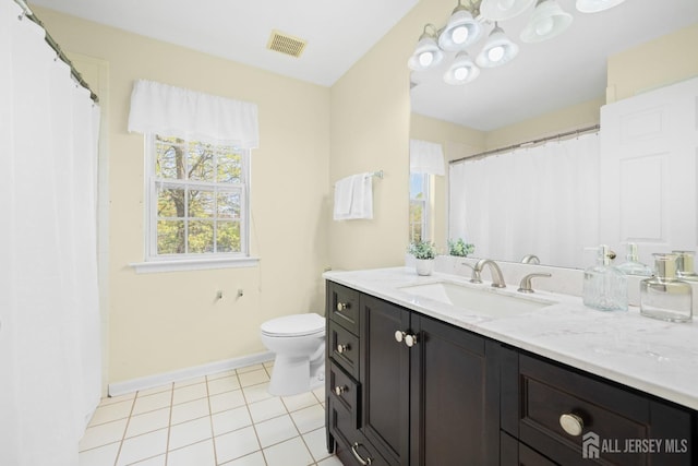 bathroom with vanity, toilet, tile patterned floors, baseboards, and visible vents