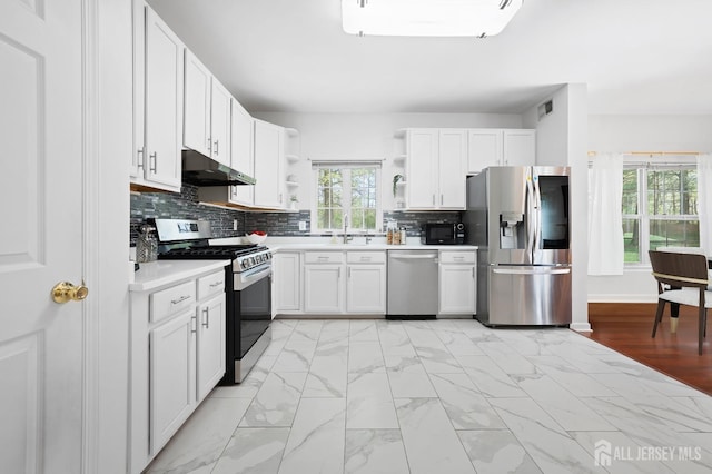 kitchen with open shelves, marble finish floor, under cabinet range hood, a sink, and appliances with stainless steel finishes