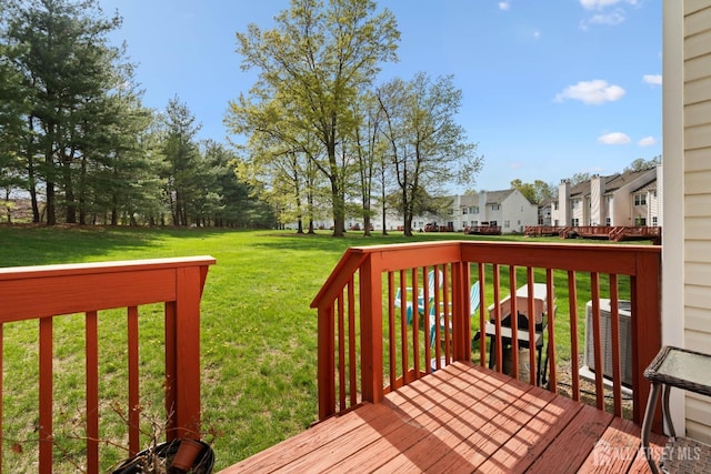wooden deck with central air condition unit, a lawn, and a residential view