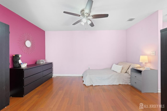 bedroom with visible vents, ceiling fan, and wood finished floors