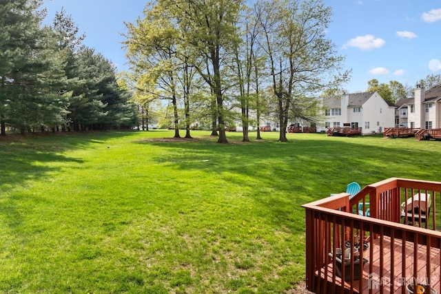 view of yard featuring a wooden deck and a residential view
