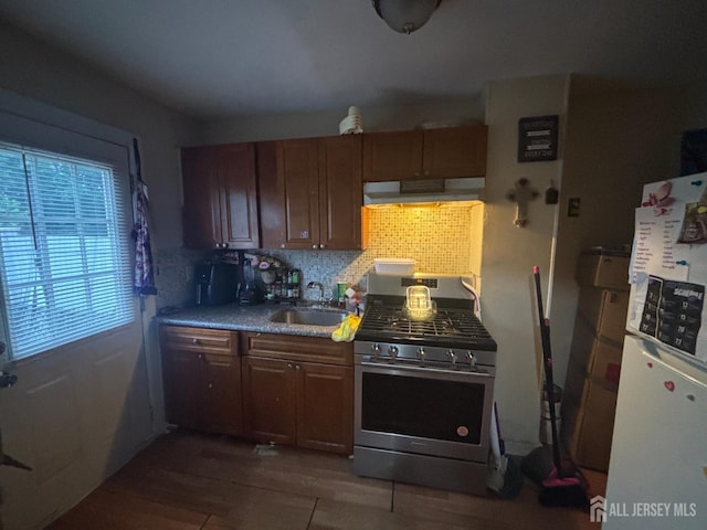 166 Fulton St, New Brunswick, NJ 08901 - kitchen with stainless steel range with gas cooktop, freestanding refrigerator, a sink, range hood, and decorative backsplash