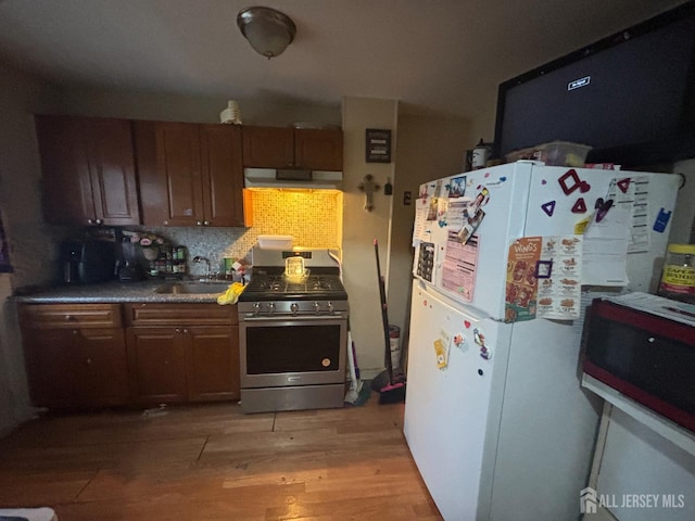 166 Fulton St, New Brunswick, NJ 08901 - kitchen with gas range, freestanding refrigerator, a sink, light wood-style floors, and backsplash