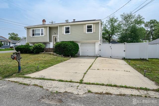 701 Beach Ave, Beachwood, NJ 08722 - bi-level home with a gate, concrete driveway, a garage, and a chimney