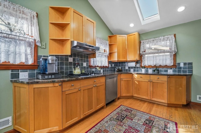 kitchen featuring vaulted ceiling with skylight, under cabinet range hood, visible vents, appliances with stainless steel finishes, and open shelves