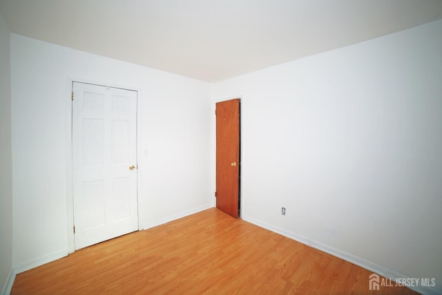 unfurnished bedroom featuring a closet and wood-type flooring