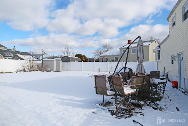 yard layered in snow with a shed