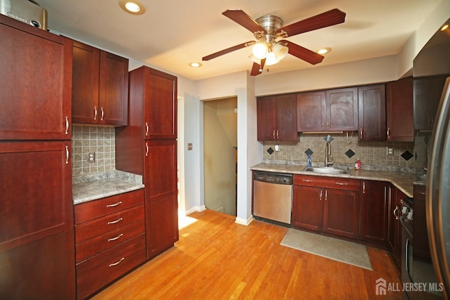 kitchen featuring sink, ceiling fan, light hardwood / wood-style flooring, stainless steel dishwasher, and light stone countertops