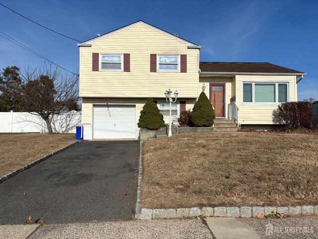 split level home featuring a front yard and a garage