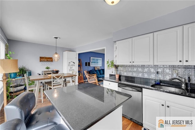 20 Karwatt Ct, Sayreville, NJ 08872 - kitchen featuring stainless steel dishwasher, white cabinets, tasteful backsplash, a center island, and dark stone countertops