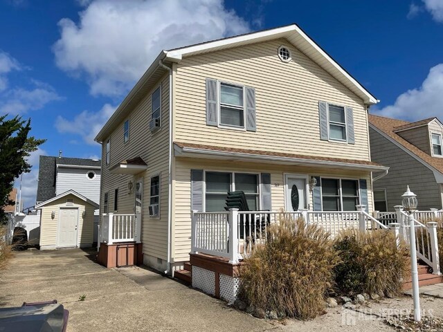 view of front of house with a storage unit and a porch