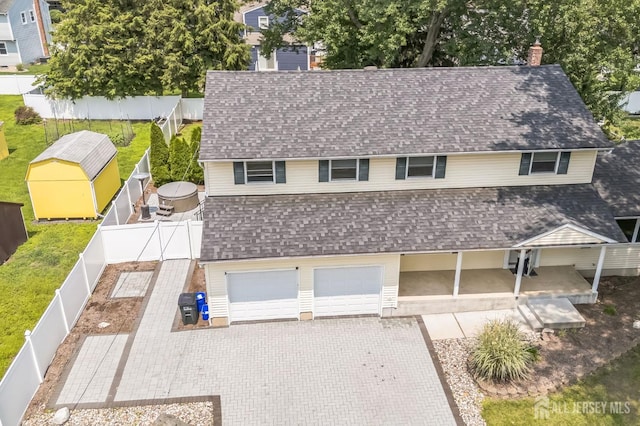 45 S Brook Dr, Milltown, NJ 08850 - view of front facade featuring a shingled roof, a chimney, a fenced backyard, decorative driveway, and a garage
