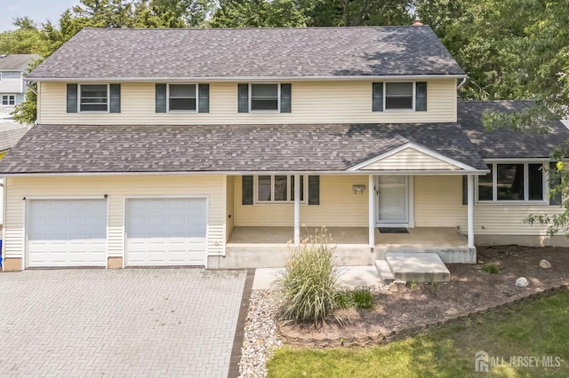 45 S Brook Dr, Milltown, NJ 08850 - view of front of house with an attached garage, decorative driveway, covered porch, and a shingled roof