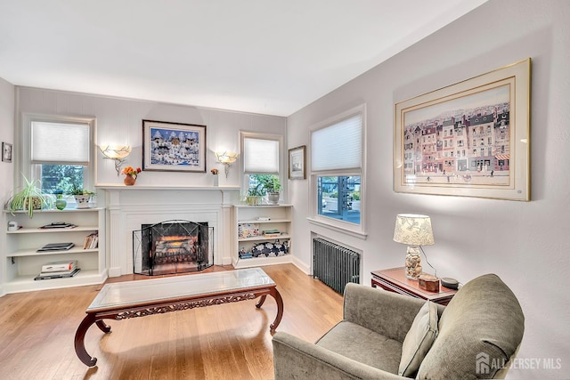 436 2nd St, Dunellen, NJ 08812 - living room with radiator heating unit, a fireplace, and wood finished floors