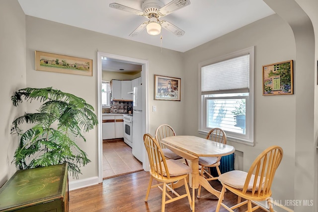 436 2nd St, Dunellen, NJ 08812 - dining space with a ceiling fan, light wood-style flooring, baseboards, and arched walkways