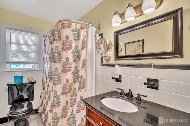 436 2nd St, Dunellen, NJ 08812 - bathroom with tile walls, vanity, curtained shower, and a wainscoted wall