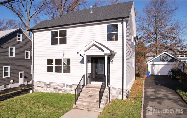 front of property with a garage and an outbuilding