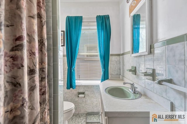 bathroom featuring tile walls, vanity, tile patterned floors, and toilet