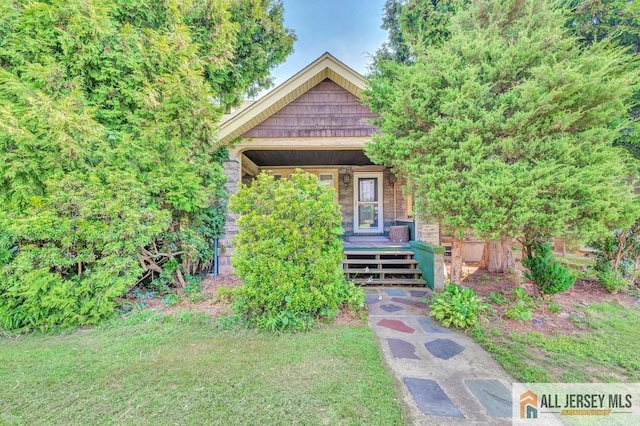 view of property hidden behind natural elements featuring covered porch