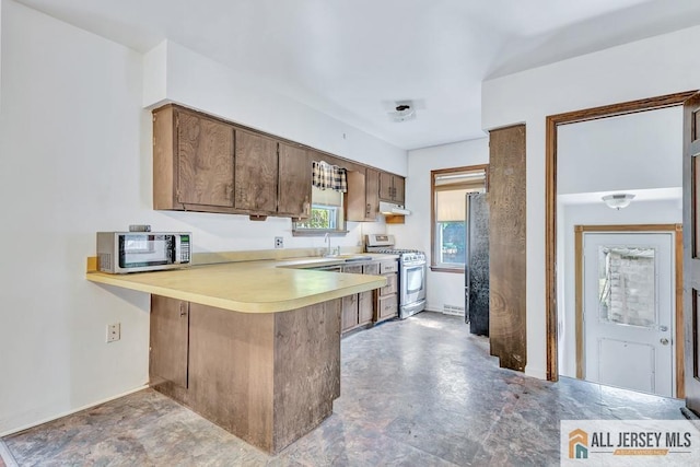 kitchen with sink, kitchen peninsula, and appliances with stainless steel finishes