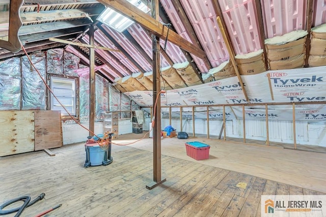 attic featuring hardwood / wood-style flooring and vaulted ceiling