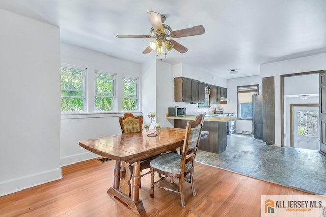 dining room with ceiling fan and light wood-type flooring