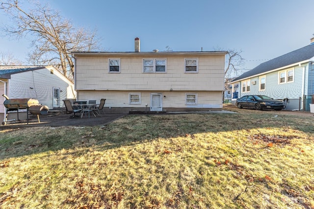 back of property with a patio area and a yard