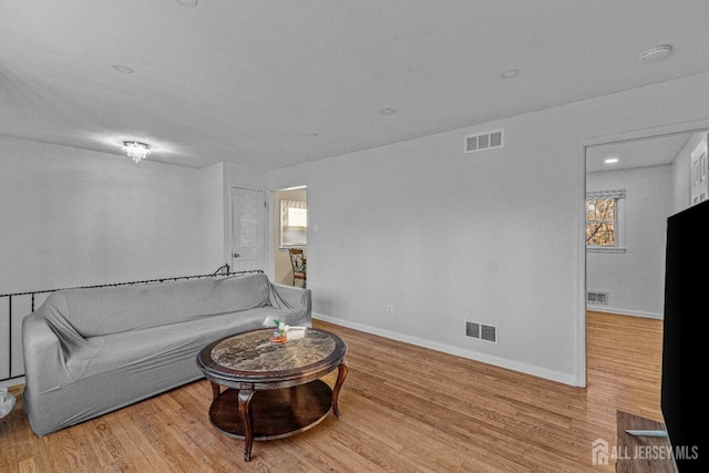 living room with a wealth of natural light and light hardwood / wood-style floors