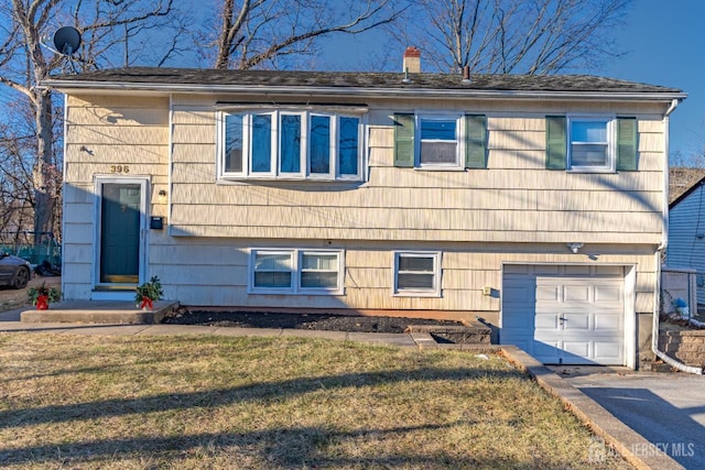 view of front of property with a front lawn and a garage