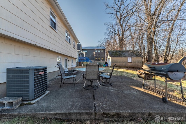 view of patio with central AC, a storage shed, and area for grilling