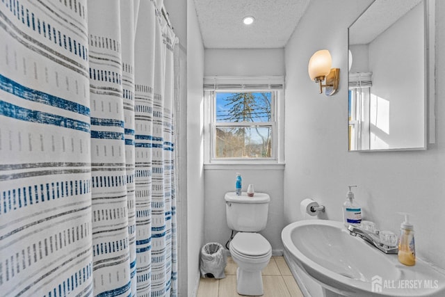 bathroom with sink, a textured ceiling, toilet, and walk in shower