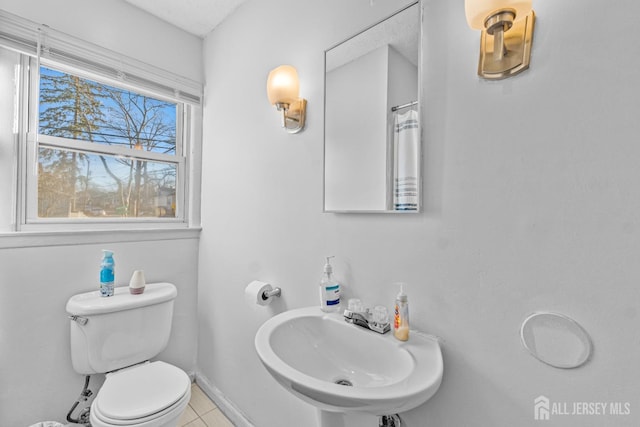 bathroom with toilet, tile patterned flooring, and sink