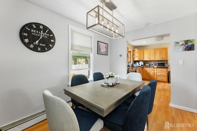 336 S Main St, Milltown, NJ 08850 - dining space with a baseboard radiator, light wood finished floors, and a chandelier
