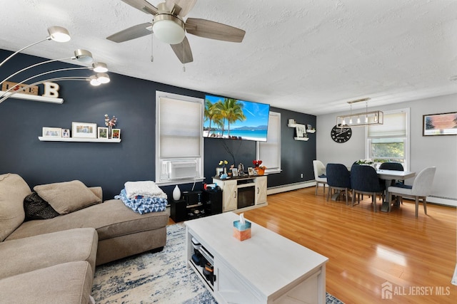336 S Main St, Milltown, NJ 08850 - living area with a baseboard heating unit, a textured ceiling, light wood finished floors, ceiling fan, and a chandelier
