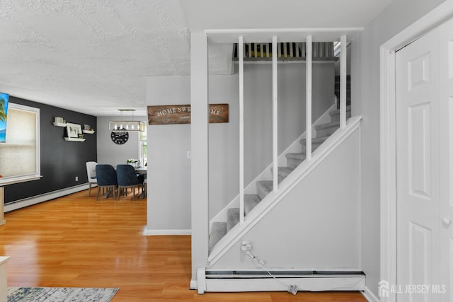 336 S Main St, Milltown, NJ 08850 - staircase with baseboard heating, wood finished floors, a textured ceiling, and a chandelier