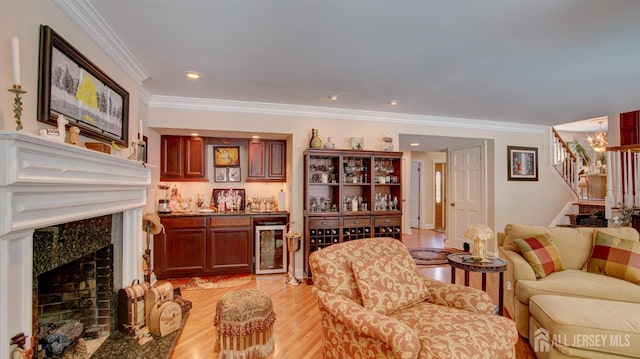 3 Feathertree Ct, Howell, NJ 07731 - living area featuring wine cooler, stairway, a premium fireplace, light wood-style floors, and crown molding