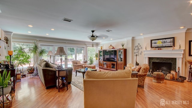 3 Feathertree Ct, Howell, NJ 07731 - living area featuring plenty of natural light, a fireplace with raised hearth, ornamental molding, light wood finished floors, and ceiling fan