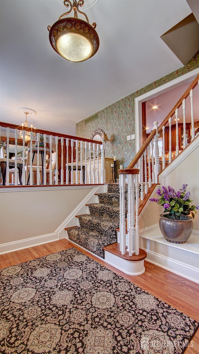 3 Feathertree Ct, Howell, NJ 07731 - staircase featuring wood finished floors, a chandelier, and wallpapered walls