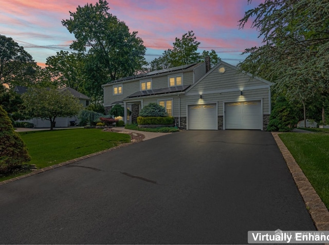 6 Schindler Ct, East Brunswick, NJ 08816 - traditional home featuring an attached garage, a chimney, a front yard, asphalt driveway, and stone siding