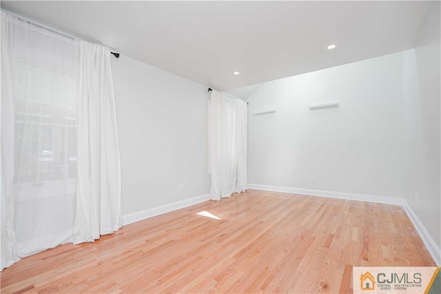 empty room featuring recessed lighting, wood finished floors, and baseboards