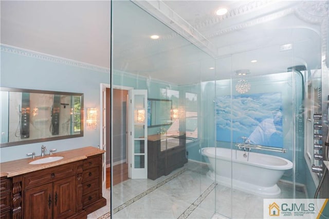 bathroom featuring a freestanding bath, vanity, and recessed lighting