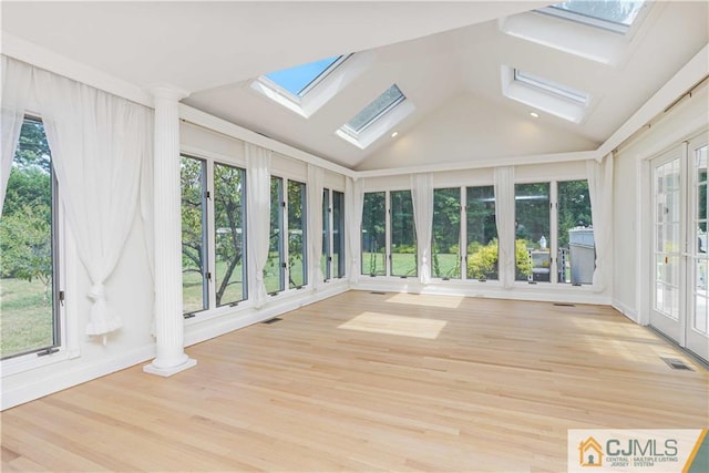 unfurnished sunroom with vaulted ceiling with skylight and visible vents