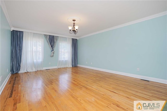 empty room with crown molding, baseboards, light wood-style flooring, and an inviting chandelier