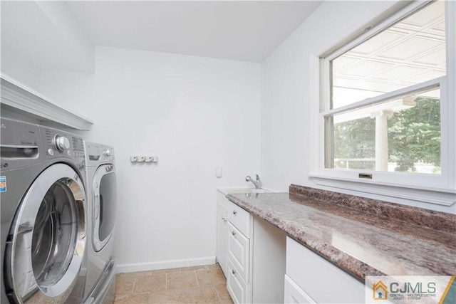 washroom with independent washer and dryer, a sink, cabinet space, and baseboards