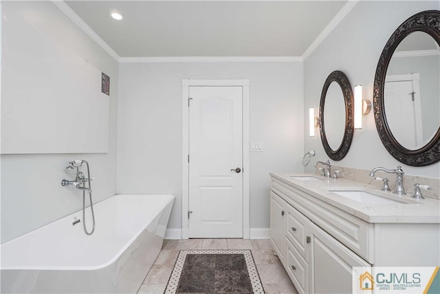 bathroom with ornamental molding, a soaking tub, and a sink